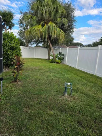Fenced backyard with lawncare items