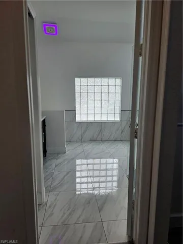 Bathroom with light marble finish flooring and vanity