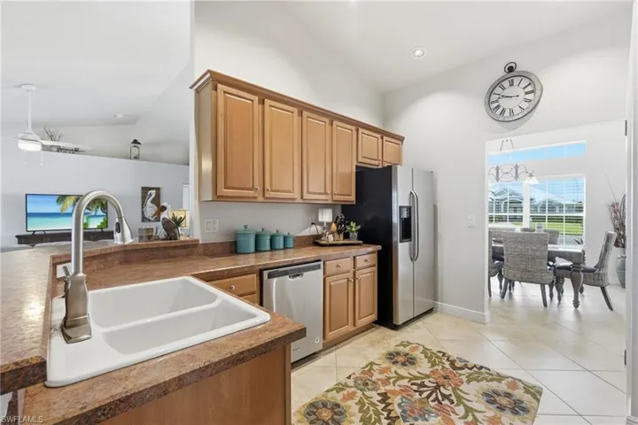 Kitchen featuring wood-finish cabinetry, a double basin sink, and stainless steel appliances