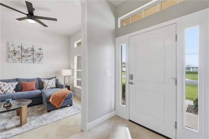 Entryway featuring a white paneled door with glass sidelights and transom windows