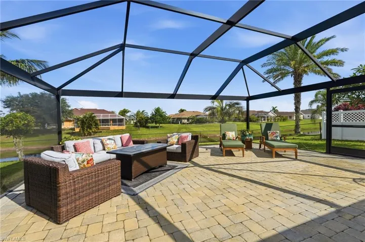 Expansive screened lanai featuring a paver patio and black aluminum framing