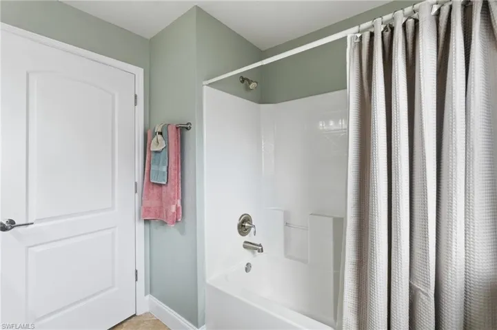 White fiberglass tub and shower combination with brushed nickel fixtures