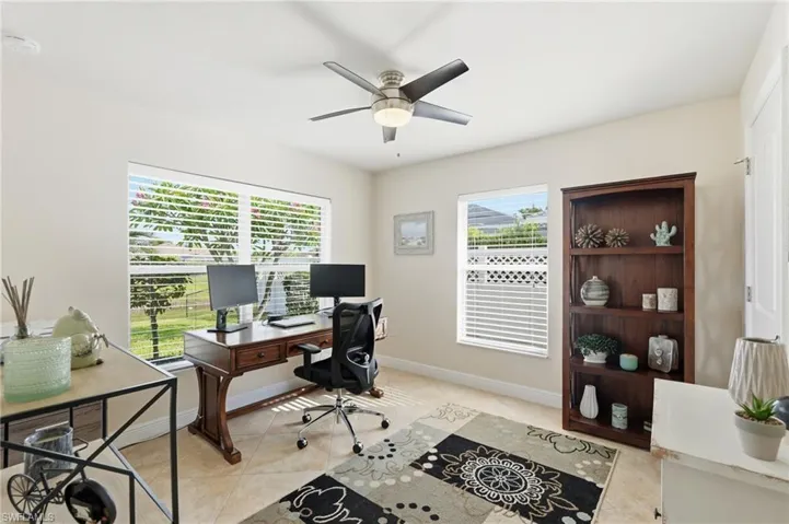 Spacious room with large windows, neutral wall tones, and tiled flooring