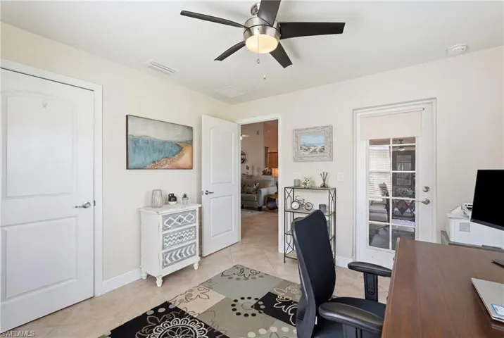 Neutral-toned interior with tile flooring and a ceiling fan with light fixture