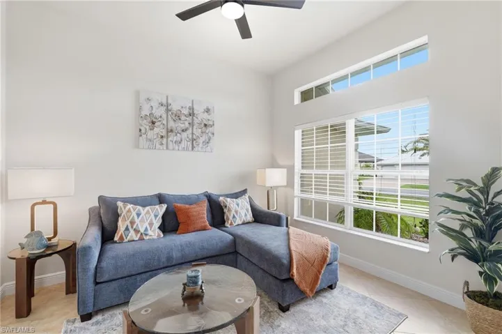 Living area featuring high ceilings, transom windows, and a ceiling fan