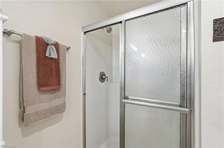 Shower enclosure featuring textured glass panels and a brushed nickel frame