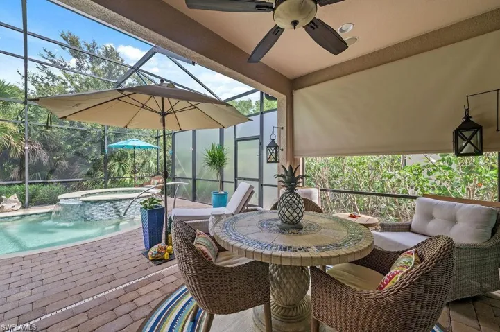 Paver deck with a swimming pool with hot tub, pool water feature, ceiling fan, a patio area, and a lanai