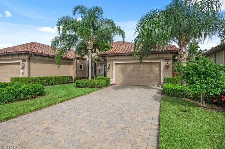Mediterranean / spanish home featuring a front lawn and a garage