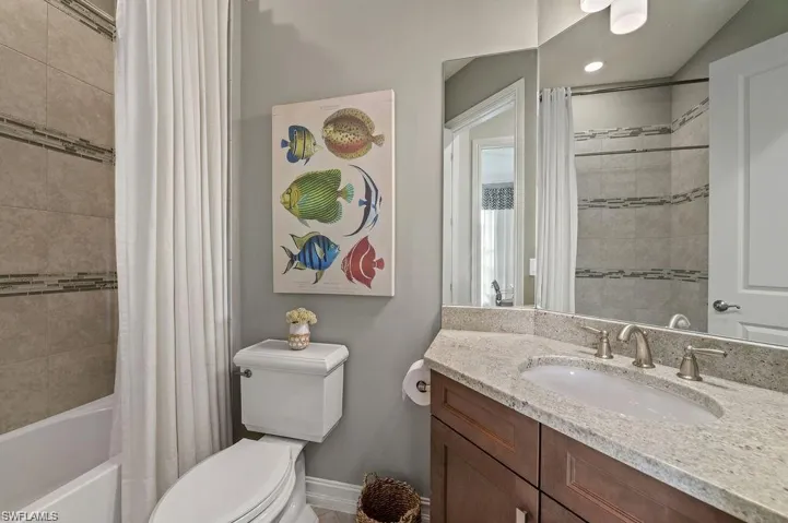 Full bathroom with vanity, toilet, and shower / bath combo