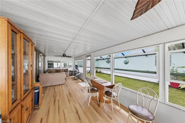 Large enclosed wraparound Florida room with impact windows and new flooring and fans installed in 2021.