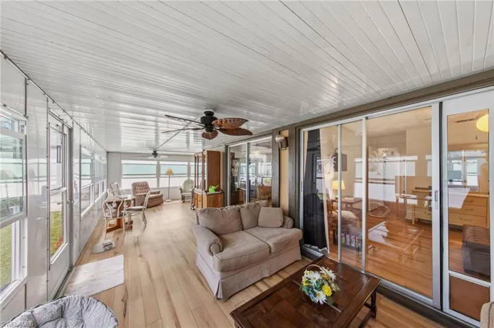 Large enclosed wraparound Florida room with impact windows and new flooring and fans installed in 2021.