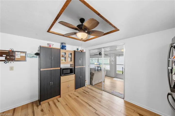 The kitchen is well-appointed with Corian solid surface countertops, tile backsplash, instant hot water dispenser, dishwasher, cooktop, built-in wall oven, and microwave. (Refrigerator does not convey with sale)