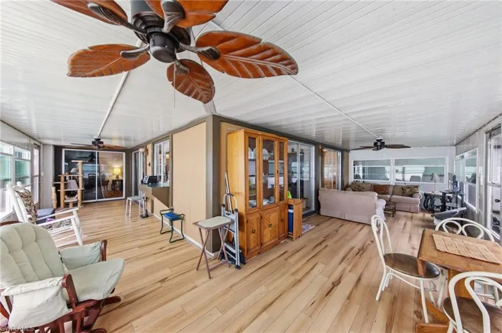 Large enclosed wraparound Florida room with impact windows and new flooring and fans installed in 2021.