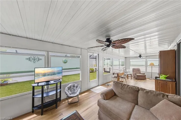 Large enclosed wraparound Florida room with impact windows and new flooring and fans installed in 2021.