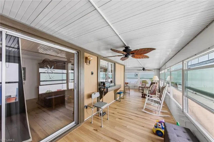 Large enclosed wraparound Florida room with impact windows and new flooring and fans installed in 2021.