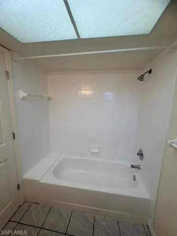 White tub and shower combination with subway tile surround