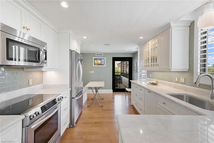 Kitchen featuring appliances with stainless steel finishes, tasteful backsplash, white cabinets, light stone counters, and recessed lighting