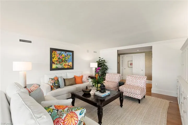 Living room with wood finished floors and crown molding