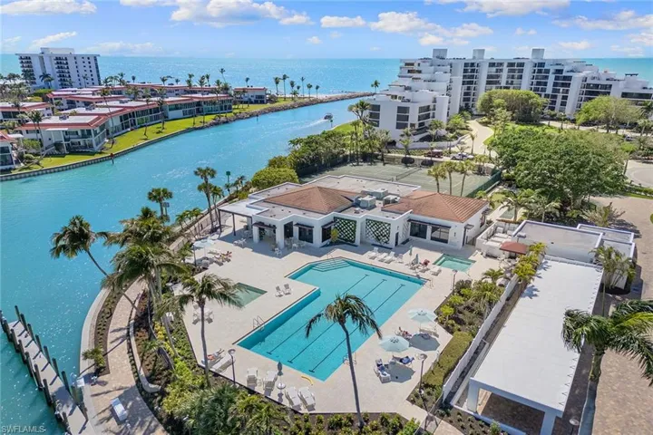 Bird's eye view of a nearby body of water and a pool area