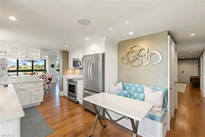 Kitchen featuring white cabinetry, stainless steel appliances, light stone countertops, light wood-type flooring, and recessed lighting