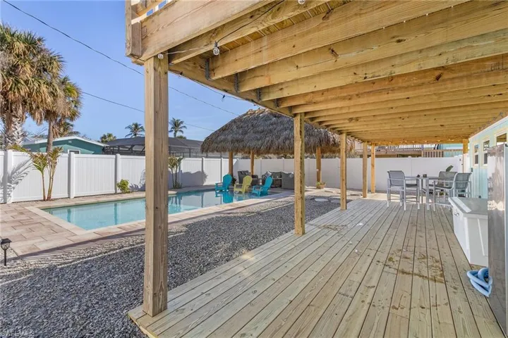 lower wooden deck with a fenced in pool and a patio.