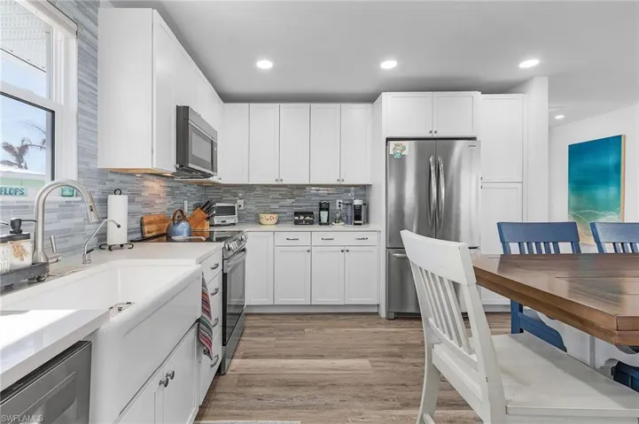 Beautiful appliances, farmers style sink with all solid surface counters and glassed backsplash.