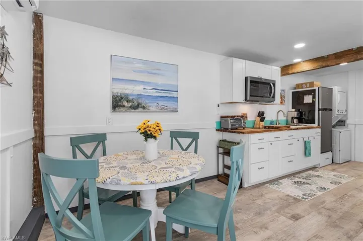 Grandfathered guest quarters with kitchen and white cabinets, stacked washer & dryer, butcher block countertops, and stainless steel appliances.