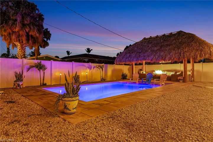 Pool at dusk featuring a patio, a fenced in pool, and a fenced backyard