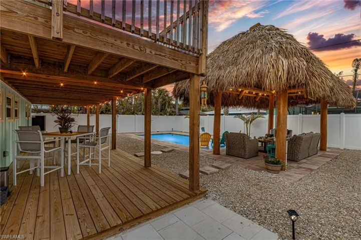 Deck at dusk with an outdoor living space, a fenced in pool, a patio area and spectacular sunsets!