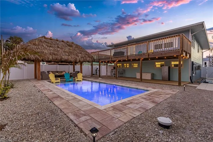 Pool at dusk featuring a patio and a deck.  This is what people move to the Beach for.