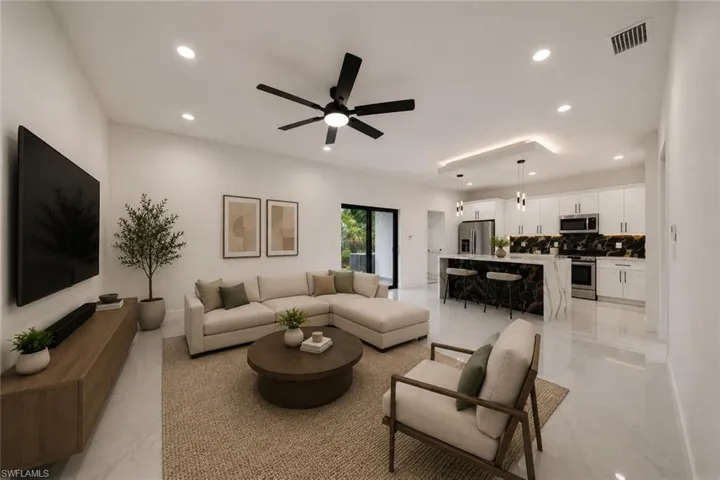 Open-concept living space with high ceilings and recessed lighting