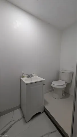 Bathroom featuring vanity and light marble finish floors