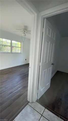 Hallway featuring dark wood finished floors and baseboards