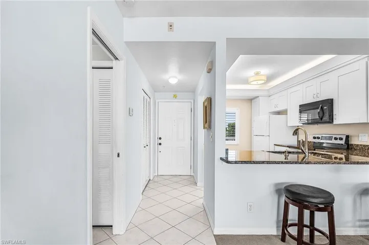 View to front door with Kitchen & bar stools @ breakfast bar