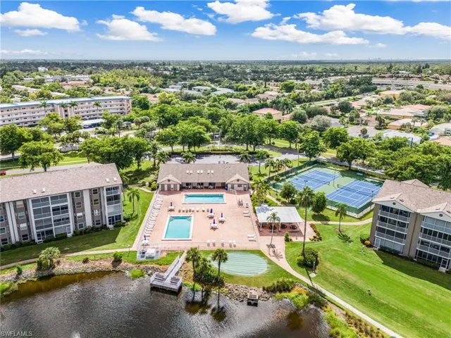 View of Clubhouse w/2 of the 3 onsite pools, dining pavilion, lighted tennis & pickleball courts, putting green, fishing pier and @ 1 tee.