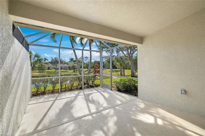 Unfurnished sunroom with a textured wall, a water view, and a textured ceiling