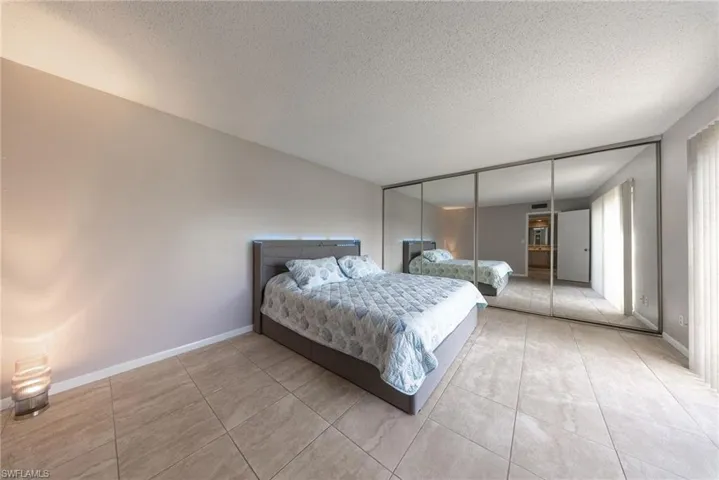 Bedroom featuring a closet, a textured ceiling, and light tile patterned floors