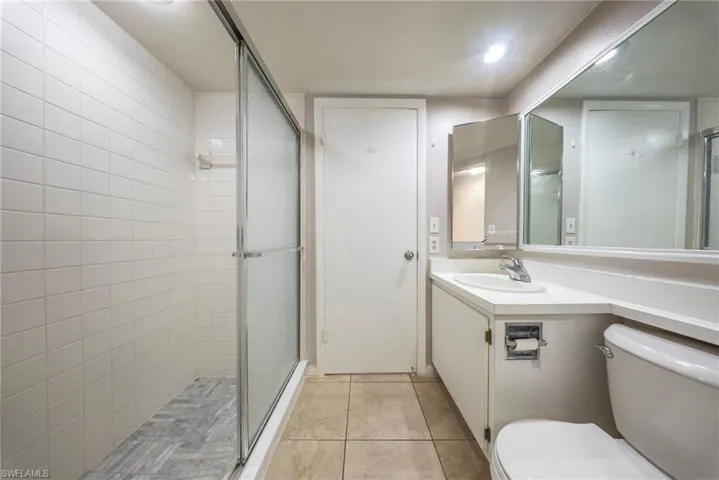 Bathroom with vanity, a stall shower, and light tile patterned flooring