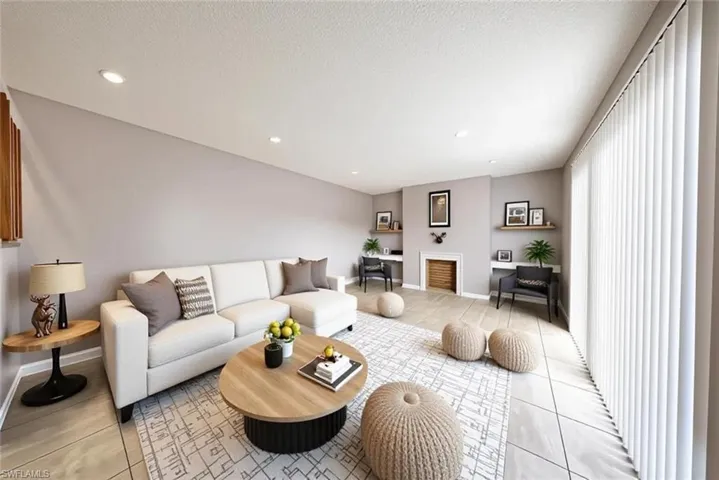 Virtually staged. Living area with recessed lighting, light tile patterned floors, and a textured ceiling