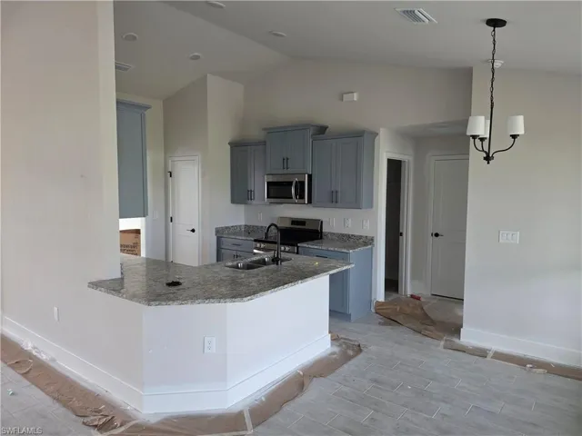 Contemporary kitchen featuring light blue cabinetry, stainless steel appliances, and a granite-style countertop