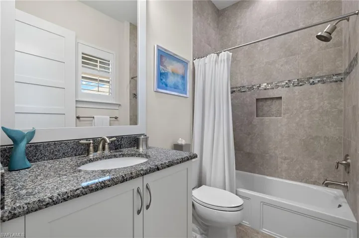 Full bathroom featuring shower / bathtub combination with curtain, vanity, and toilet