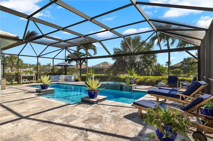 View of pool featuring a patio and glass enclosure