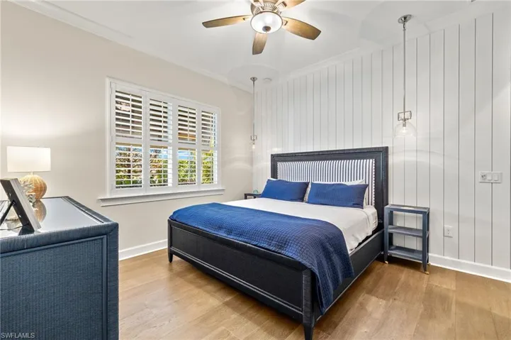 Bedroom with ceiling fan, ornamental molding, and hardwood / wood-style floors