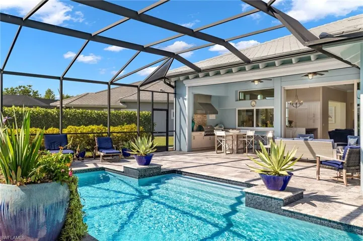 View of pool with glass enclosure and a patio
