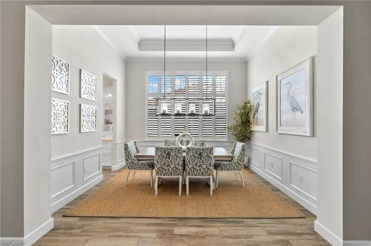 Dining area with a raised ceiling and wood-type flooring
