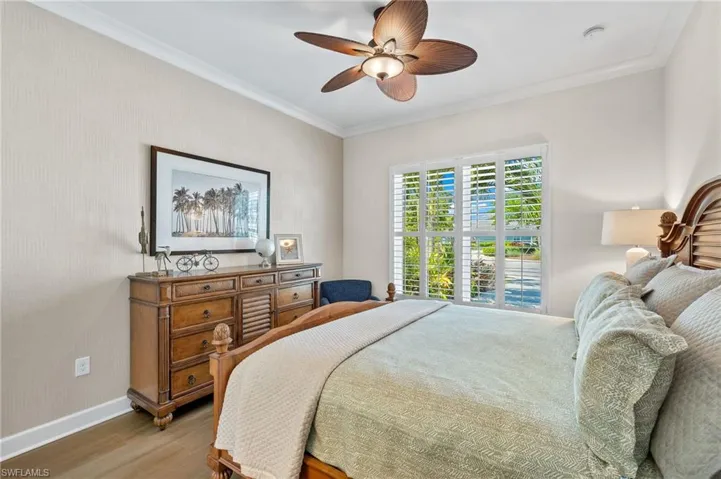 Bedroom featuring crown molding, wood-type flooring, and ceiling fan