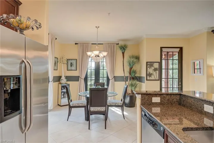 Dining area with light tile patterned flooring, crown molding, and french doors