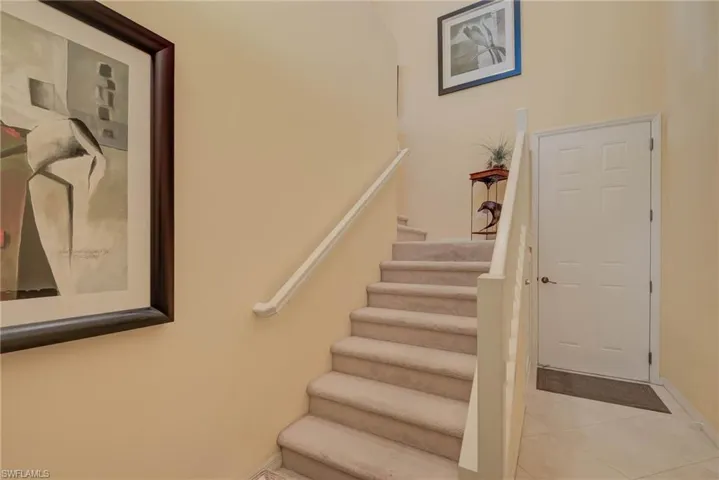 Staircase with tile patterned floors and baseboards