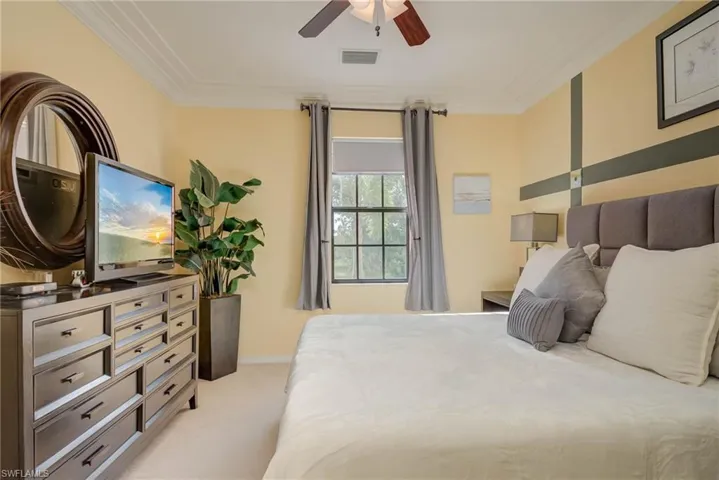 Bedroom featuring crown molding, light colored carpet, and a ceiling fan