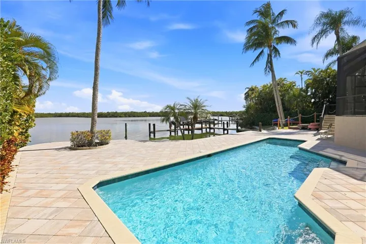 Heated Swimming pool featuring expanded paver decking and bay view. ai